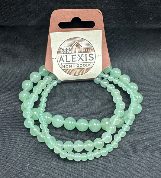 Close-up image of a 3-pack aventurine bracelet set from Alexis Home Goods, featuring beads in 4mm, 6mm, and 8mm sizes. Each bracelet showcases the soft green hues of aventurine stones, known for their smooth finish and connection to prosperity and heart-centered energy. The stretchy design ensures a comfortable fit for most wrist sizes