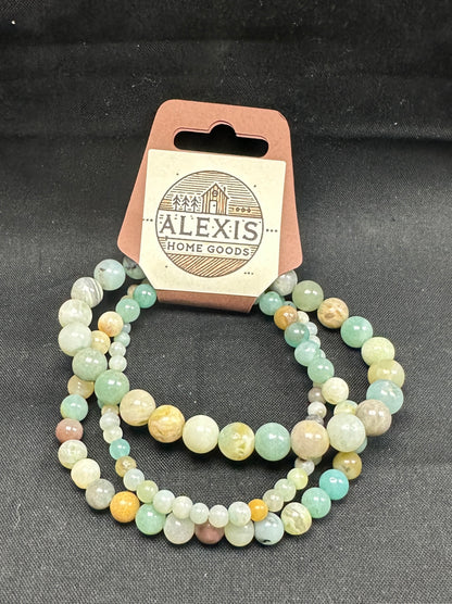 Close-up image of a 3-pack amazonite bracelet set from Alexis Home Goods, featuring beads in 4mm, 6mm, and 8mm sizes. Each bracelet showcases the soothing shades of aqua, teal, and pale green characteristic of amazonite stones, celebrated for their calming and communication-enhancing properties. The stretchy design ensures a comfortable fit for most wrist sizes.